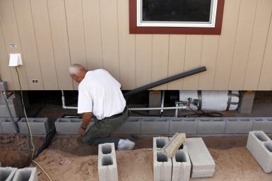 man-insulating-water-pipes-under-home-157435206.jpg