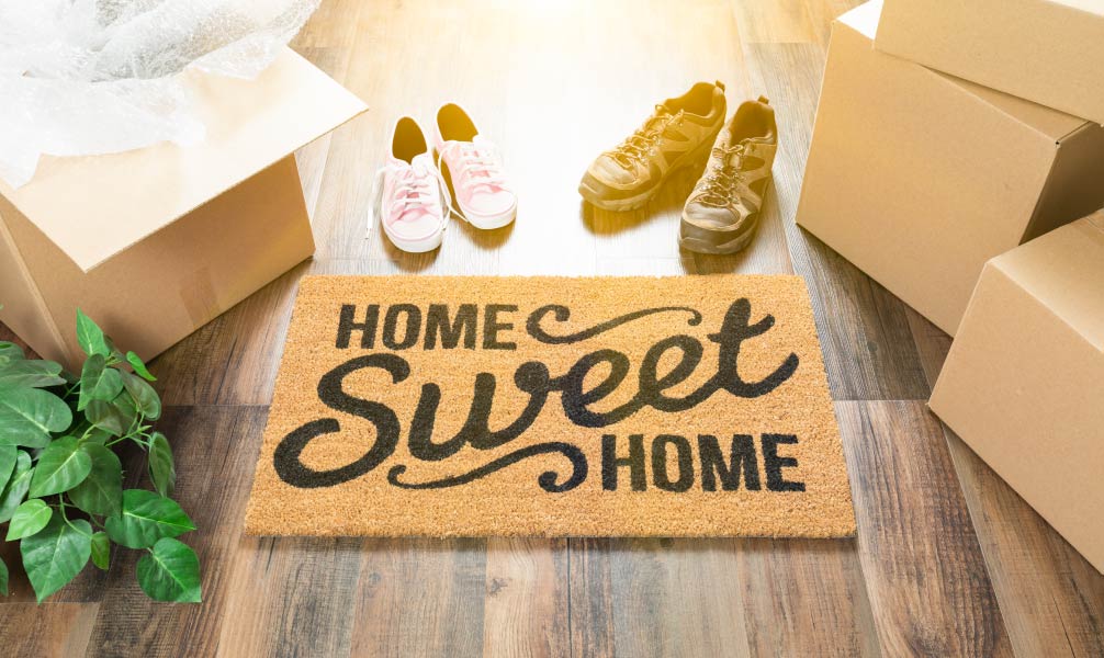resized_FI_GettyImages-962708860_Home-Sweet-Home-welcome-mat-moving-boxes-and-shoes-new-home